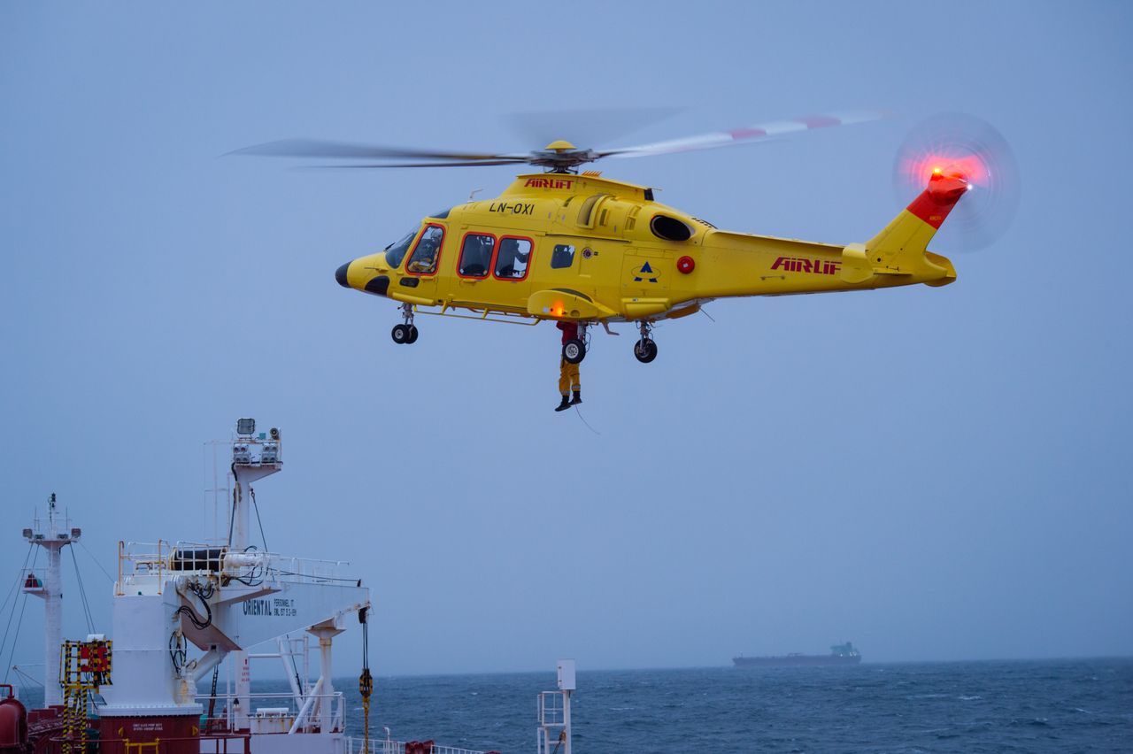 Mastering the First Impression: Your intriguing post title goes here A yellow rescue helicopter hovers over a ship during an aerial operation over choppy waters.